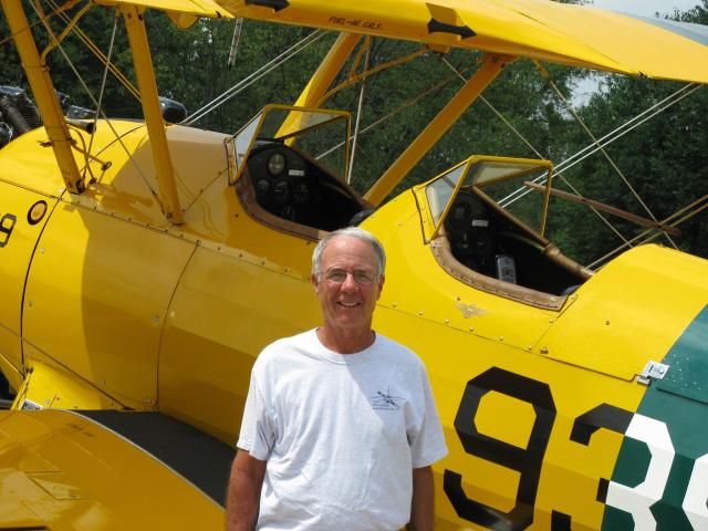 Former Naval Aviator and Air Zoo Board Member Alan Wright poses in front of his Stearman Bi-Plane